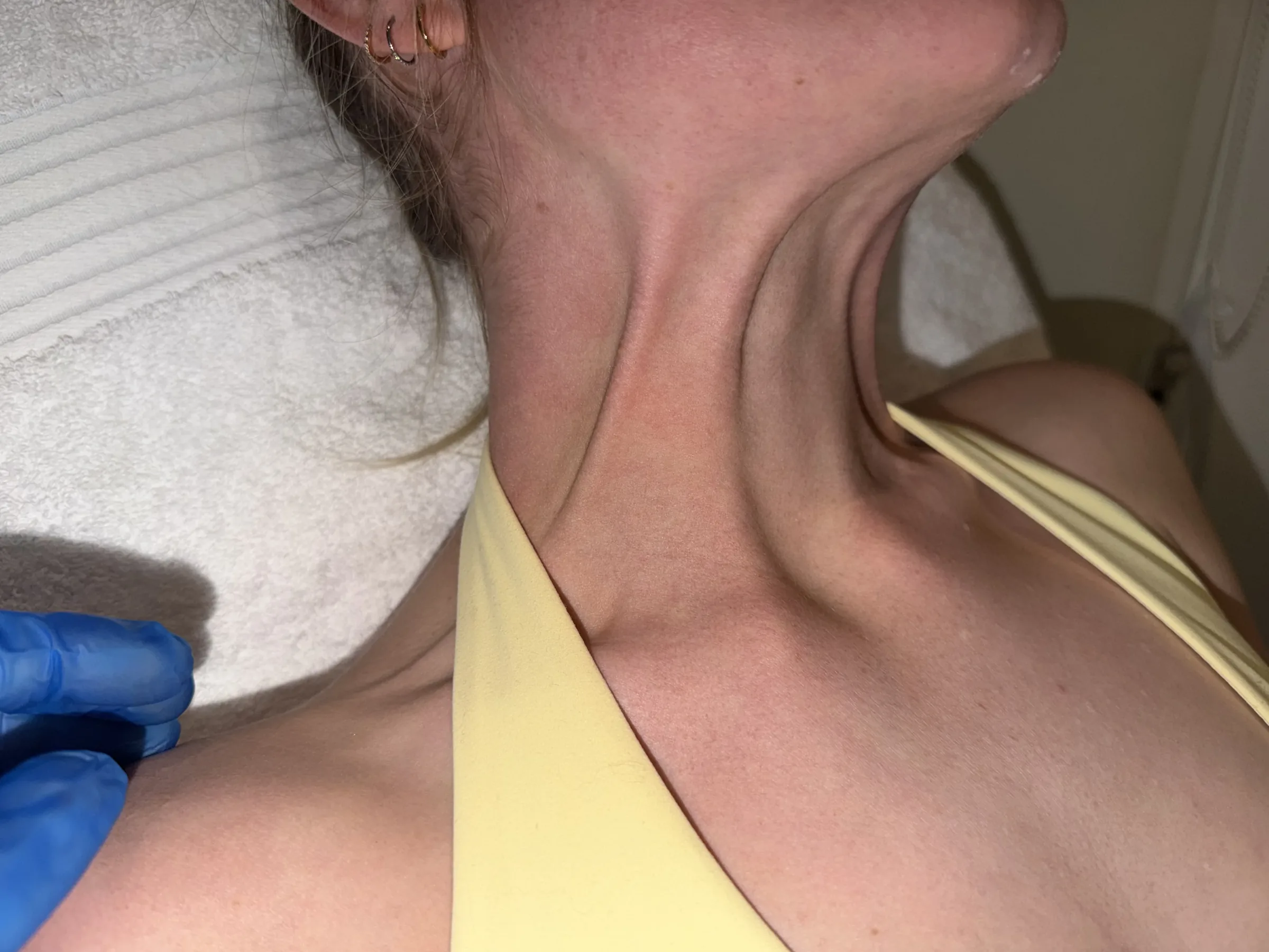 Adult staff model showing natural neck movement during an assessment at Core Aesthetics