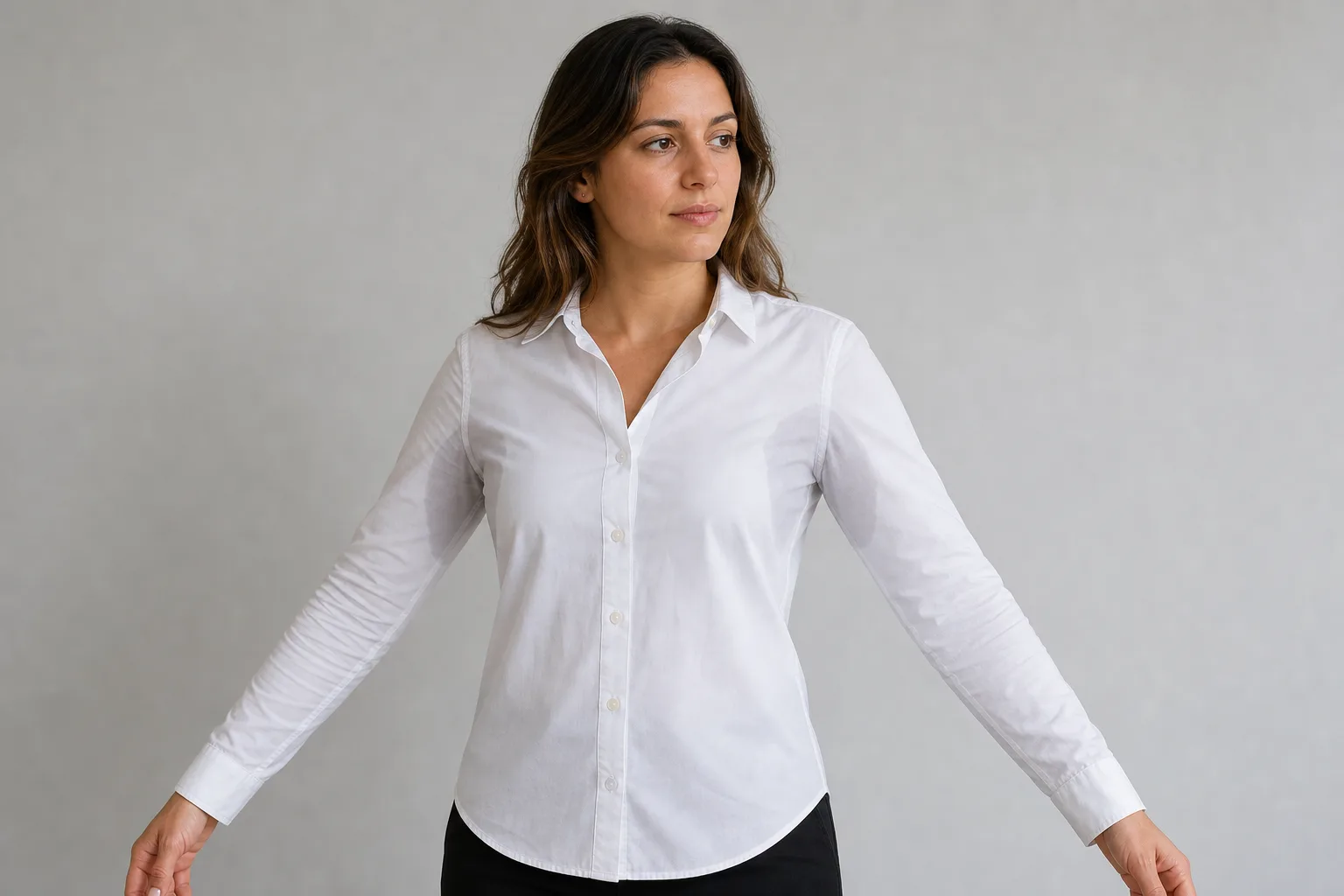 Adult in a white shirt showing the underarm area discussed in a sweating consultation.