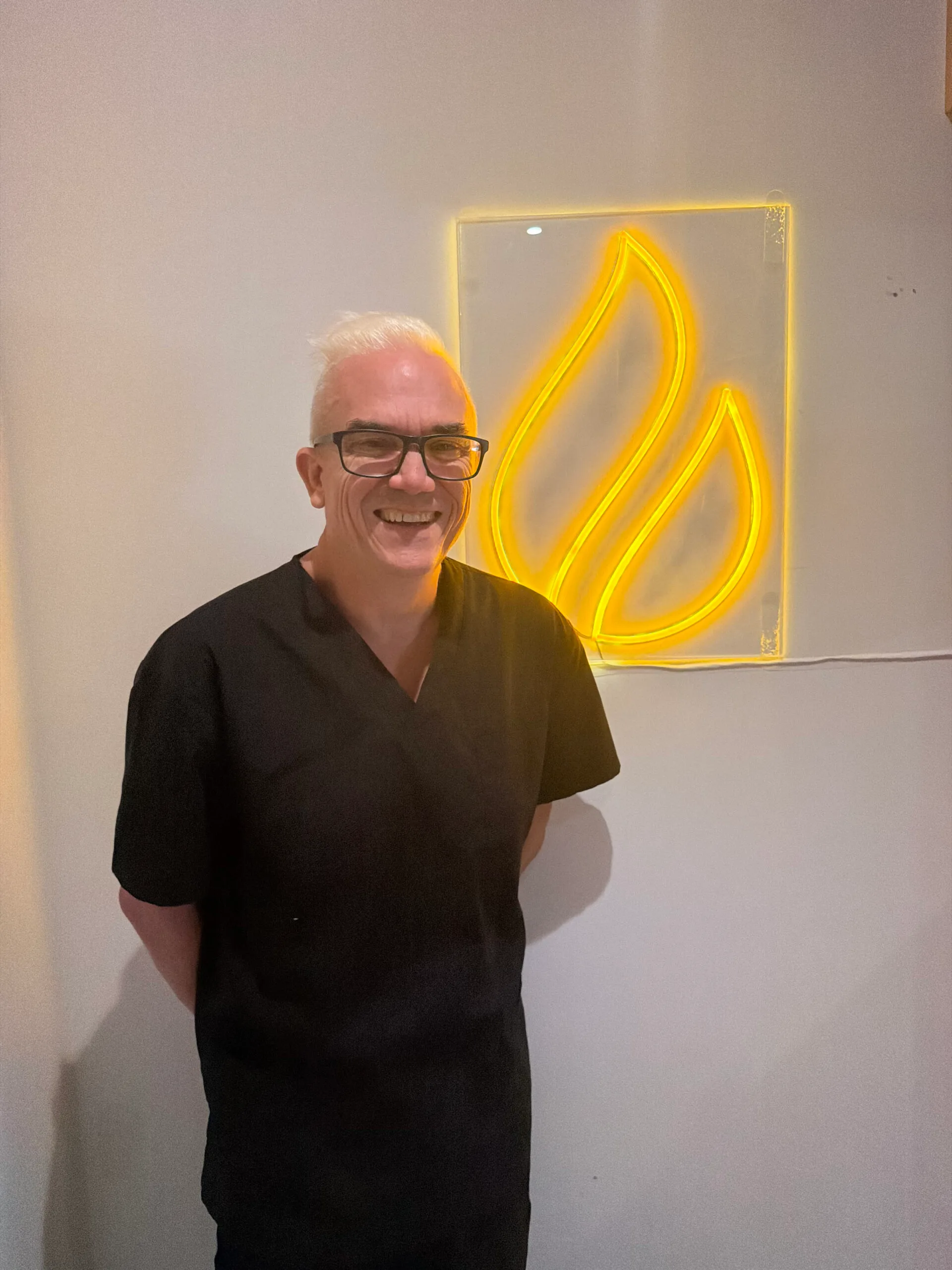 Corey Anderson RN standing beside the Core Aesthetics sign inside the Oakleigh clinic