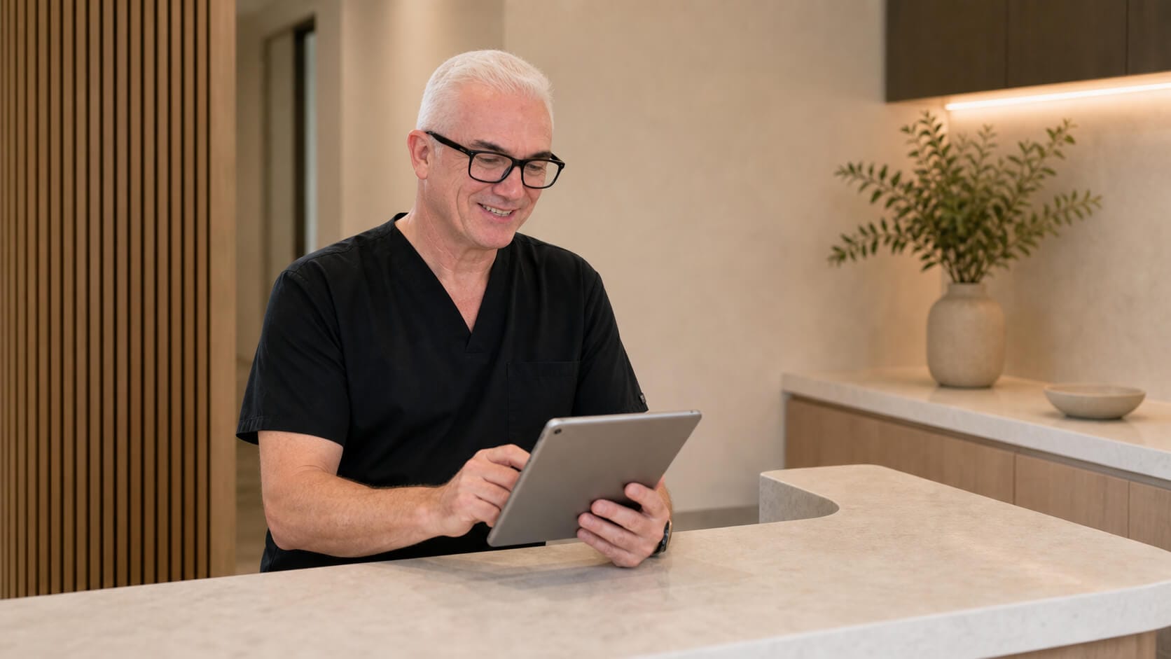 Corey Anderson RN reviewing clinic information on a tablet at the Oakleigh consultation counter