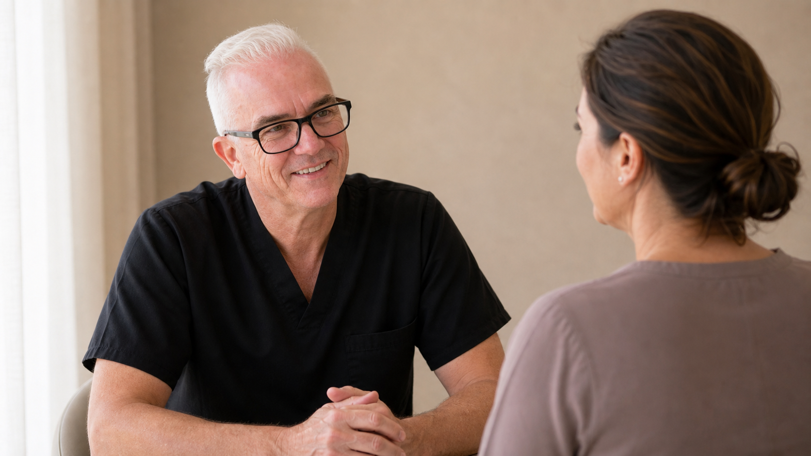 Corey Anderson RN speaking with an adult patient during a facial assessment consultation