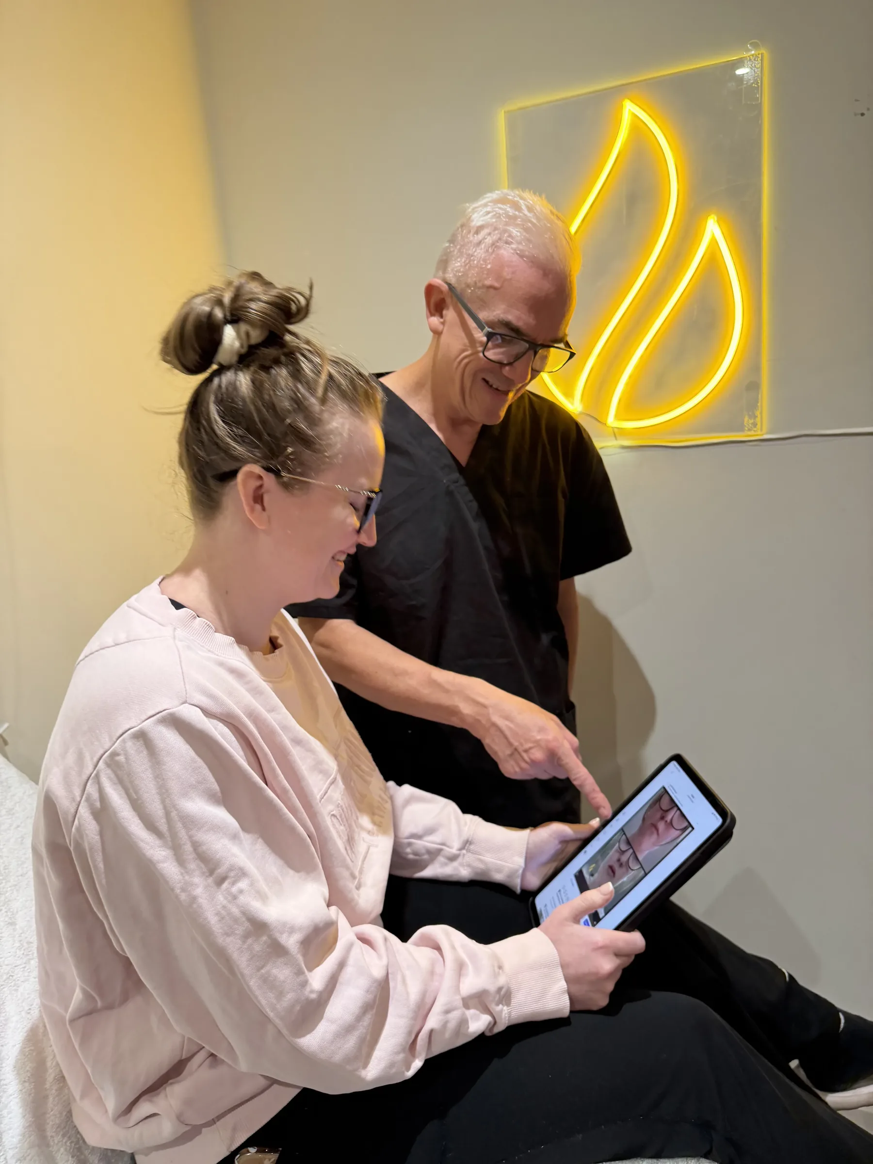 Corey Anderson RN reviewing lip consultation planning information at Core Aesthetics Oakleigh