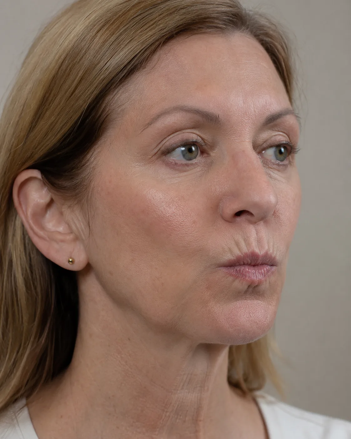 Older adult woman gently pursing her lips during an educational movement assessment