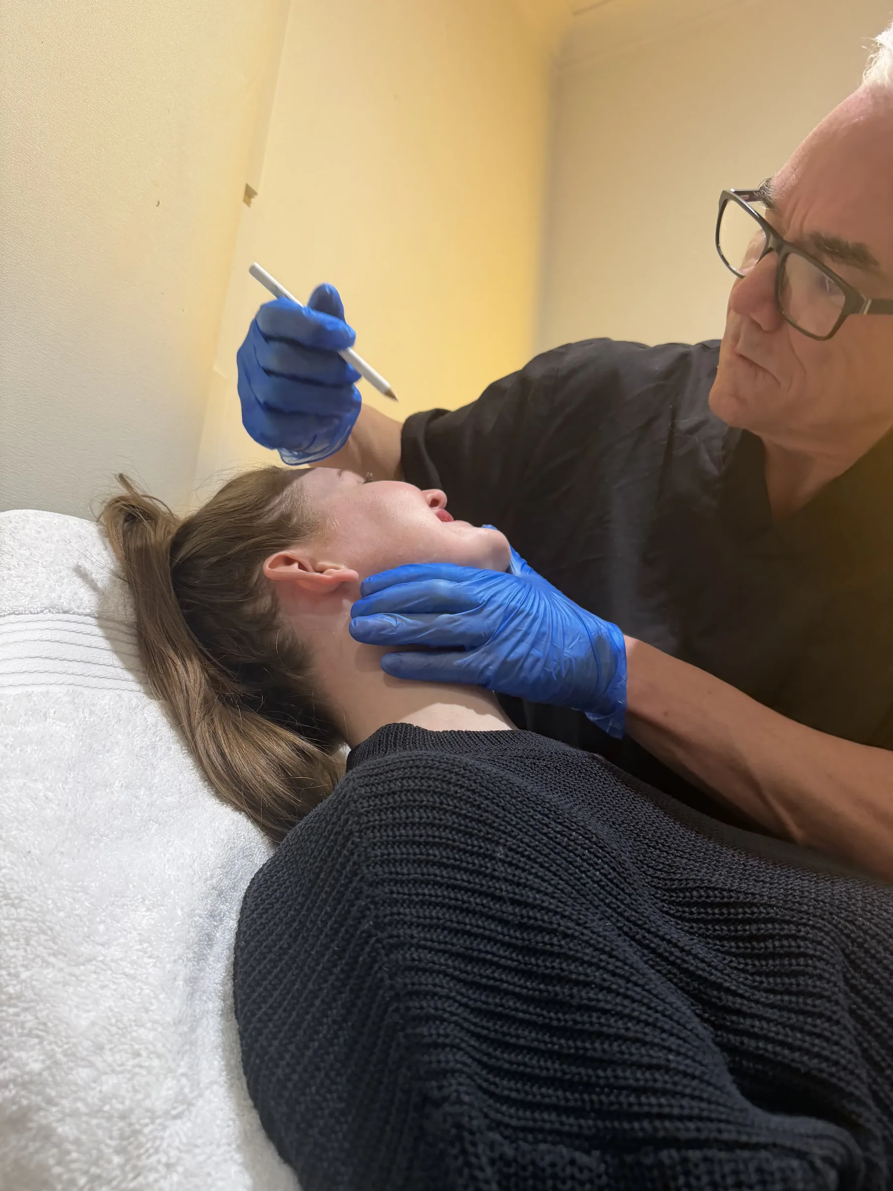 Corey Anderson RN speaking with an adult patient during a private facial consultation in Oakleigh