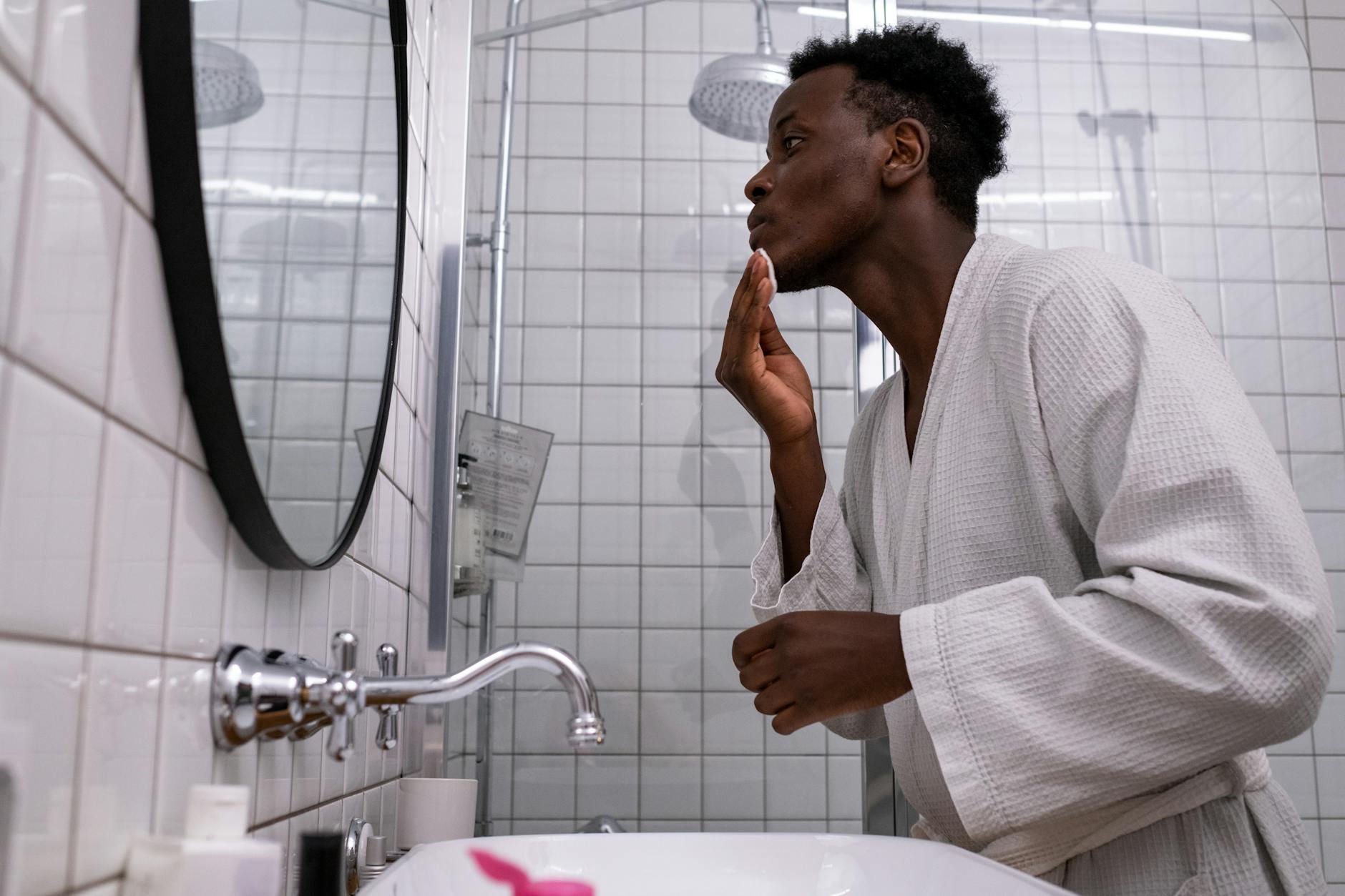 Man following a personal grooming routine in a bathroom setting.