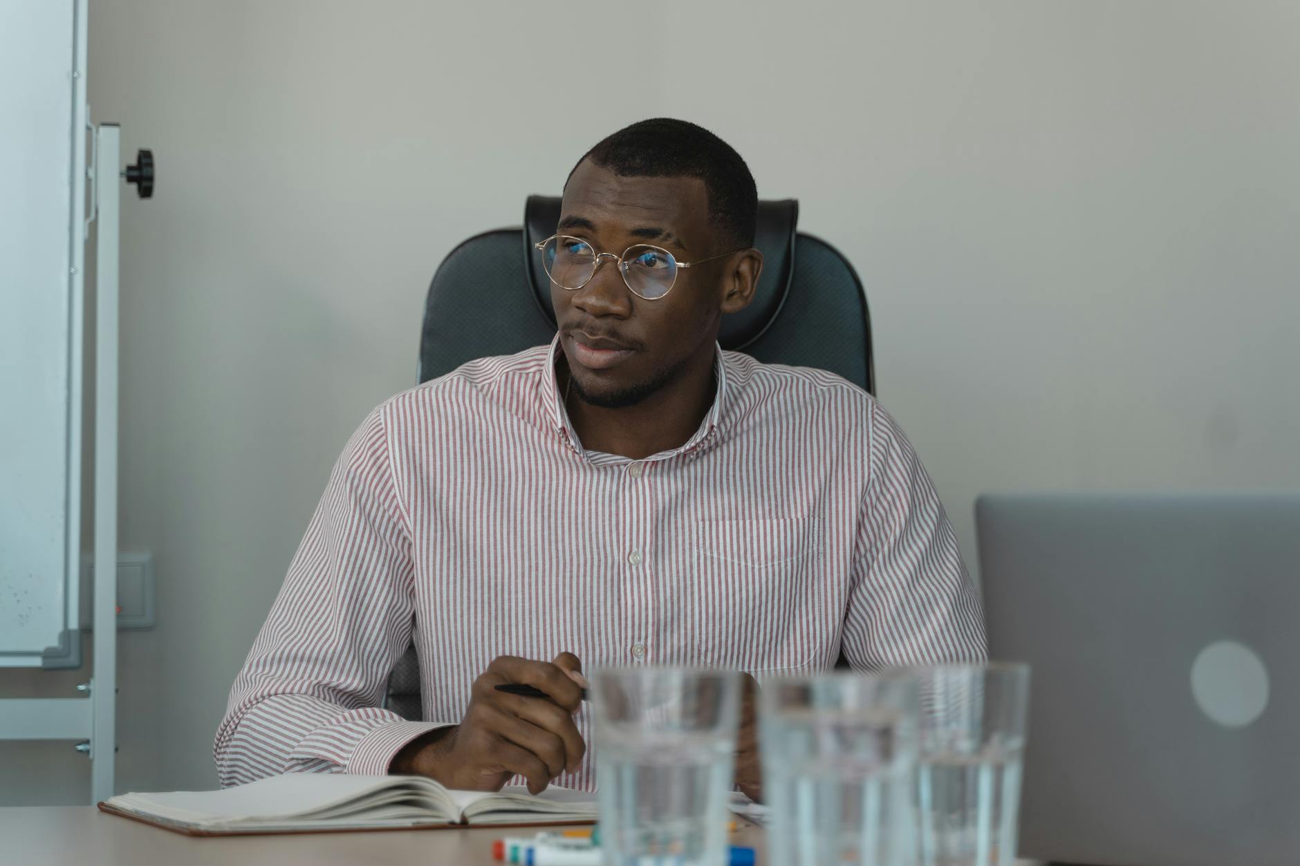 Man seated in a workplace setting while managing private discomfort.