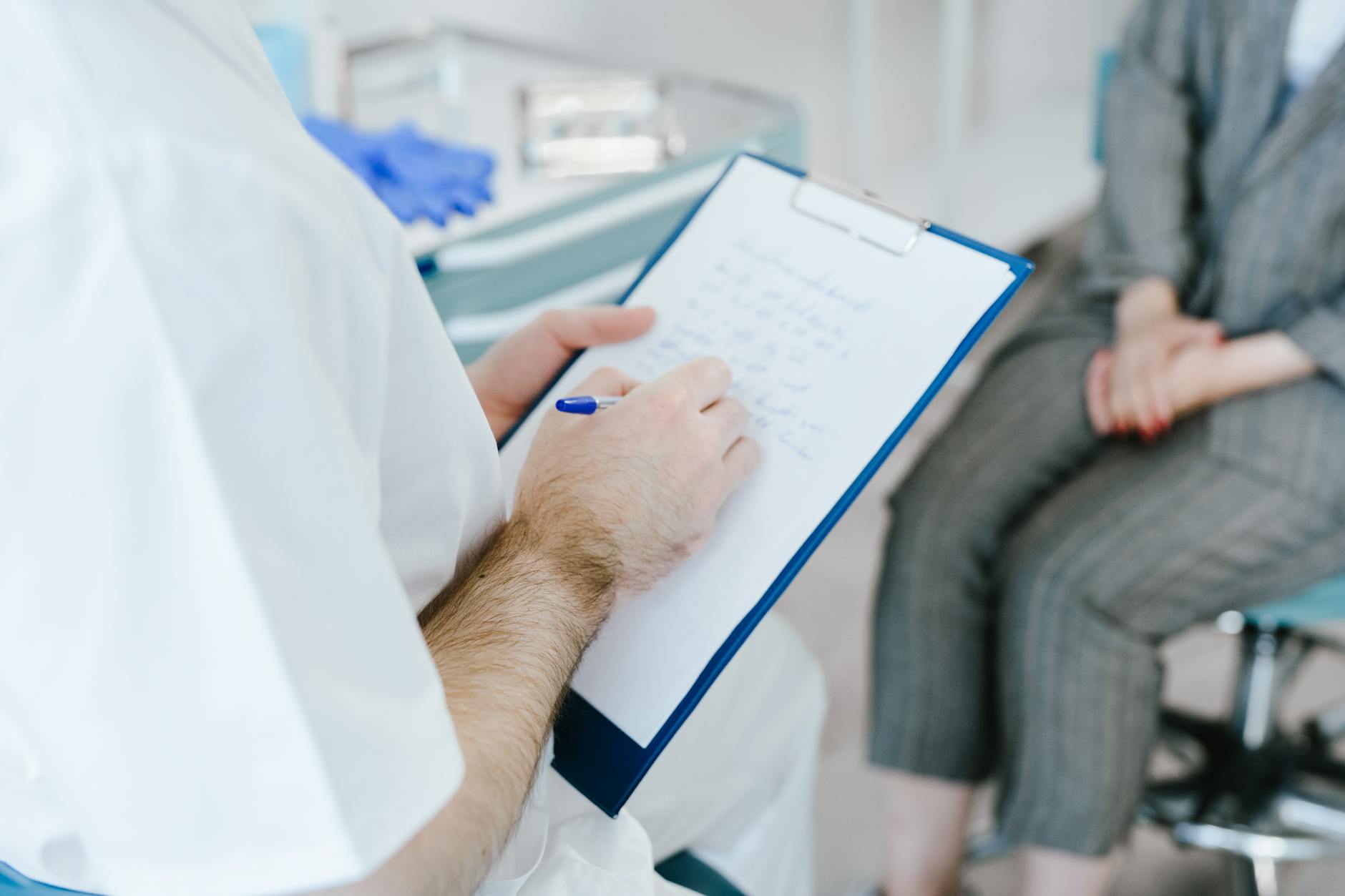 Clinician taking notes during a structured consultation