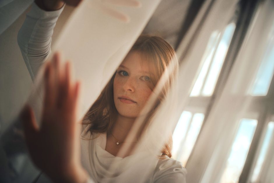 Adult in a calm reflective moment in a modern indoor setting.