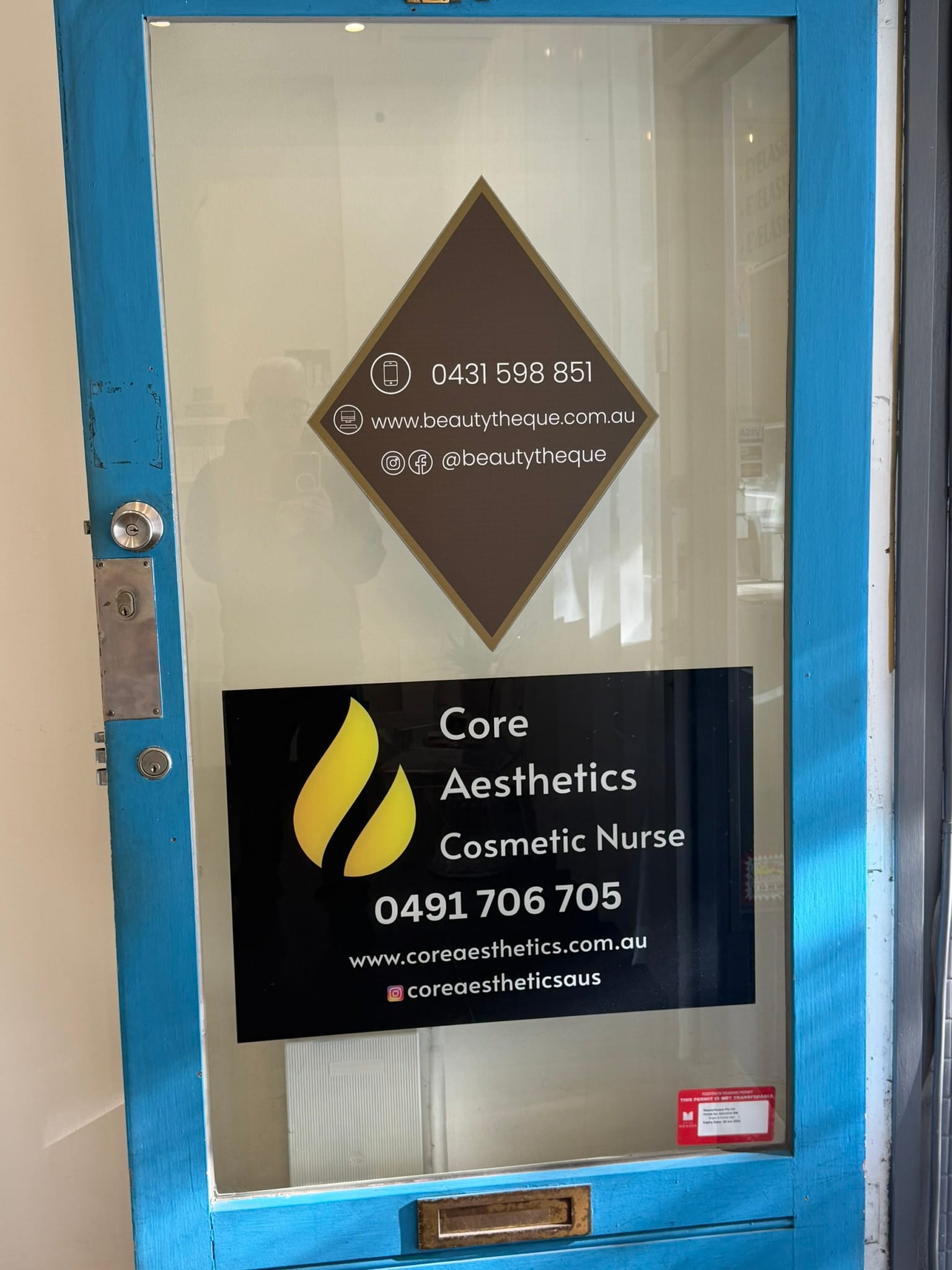 Genuine Atherton Road entrance door showing the Core Aesthetics business name and contact number