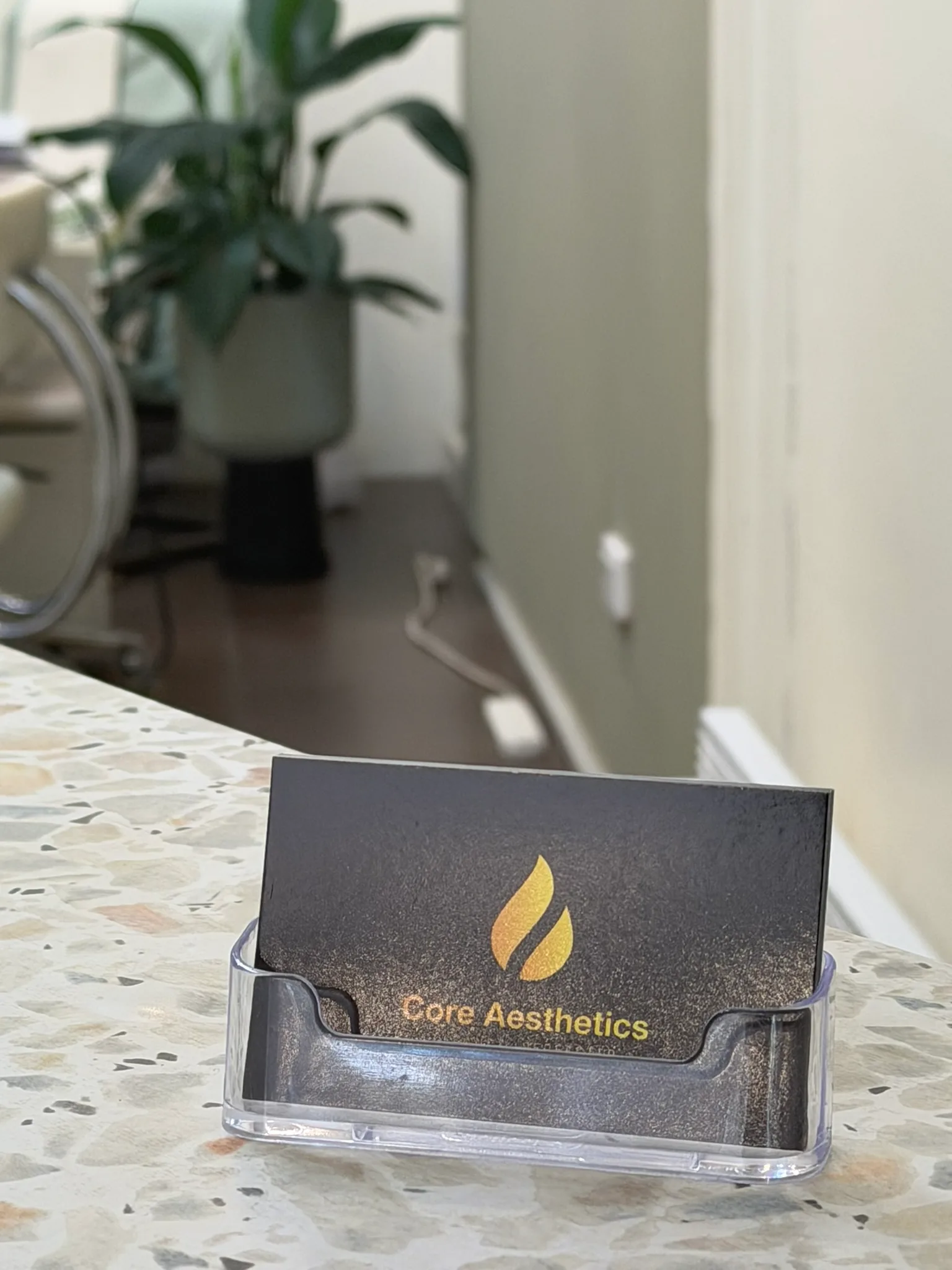Genuine Core Aesthetics business card at the Oakleigh reception desk used to confirm clinic contact details
