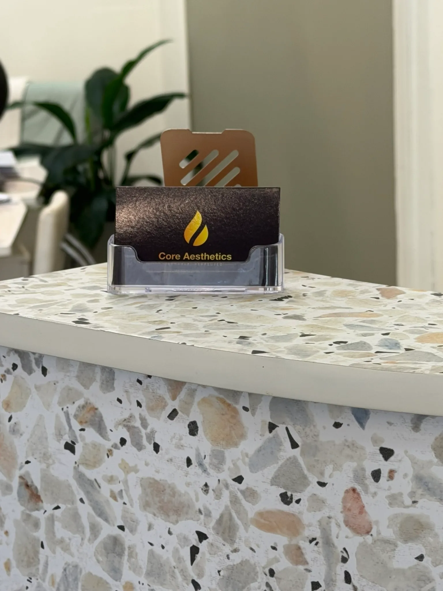 Core Aesthetics card display at the genuine Oakleigh reception counter for verifying the nursing clinic contact route