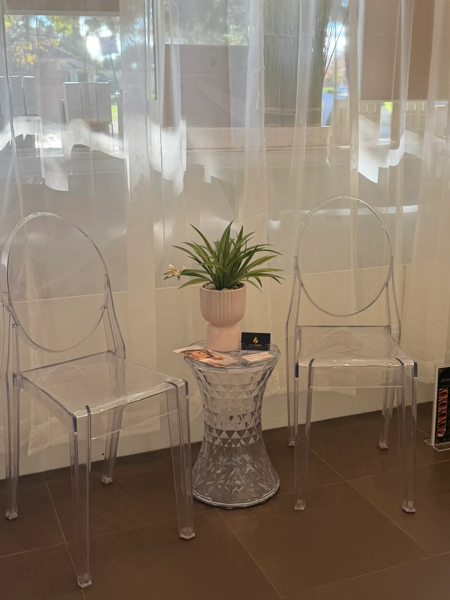Clear chairs in the genuine Core Aesthetics waiting area beside the Oakleigh clinic window